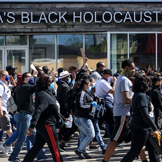 group of people marching in front of America's Black Holocaust Museum