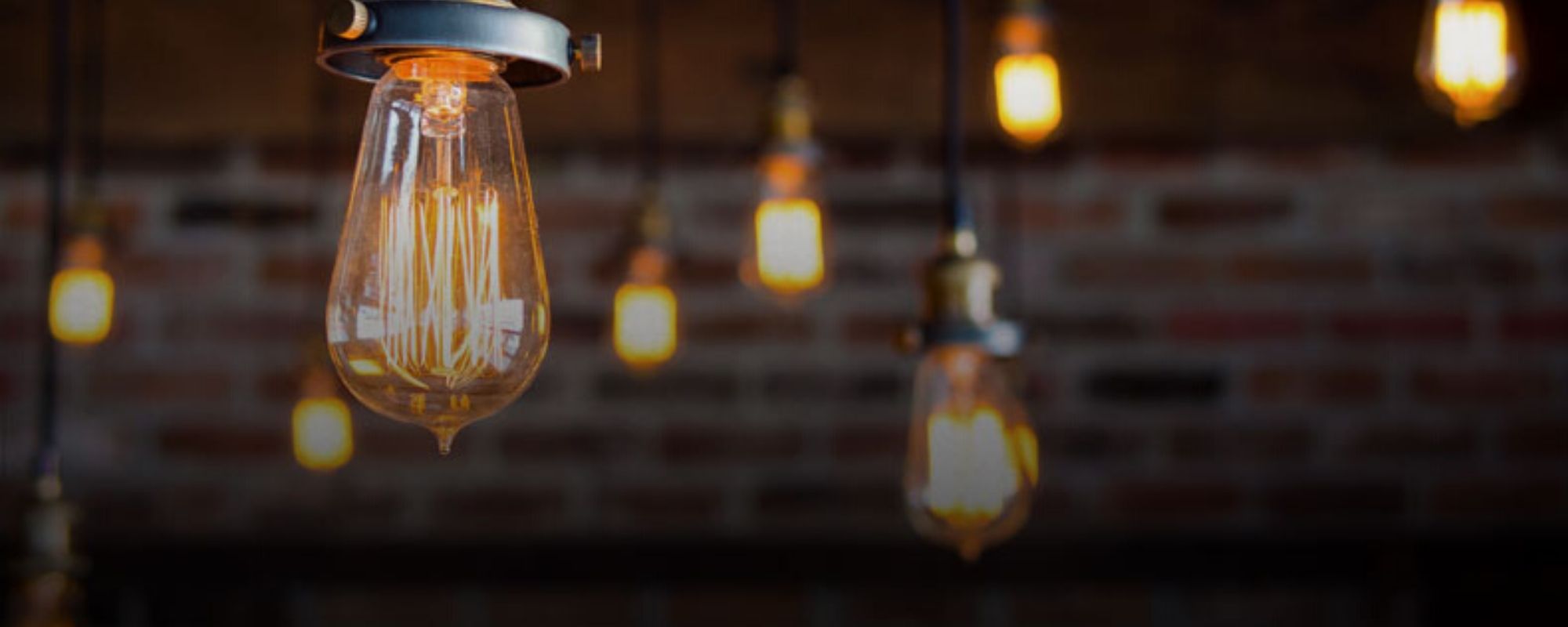 close up of a lightbulb with blurred ceiling in the background with more lights