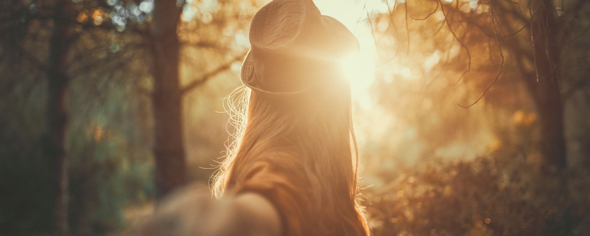 woman guiding through a sunlit forest