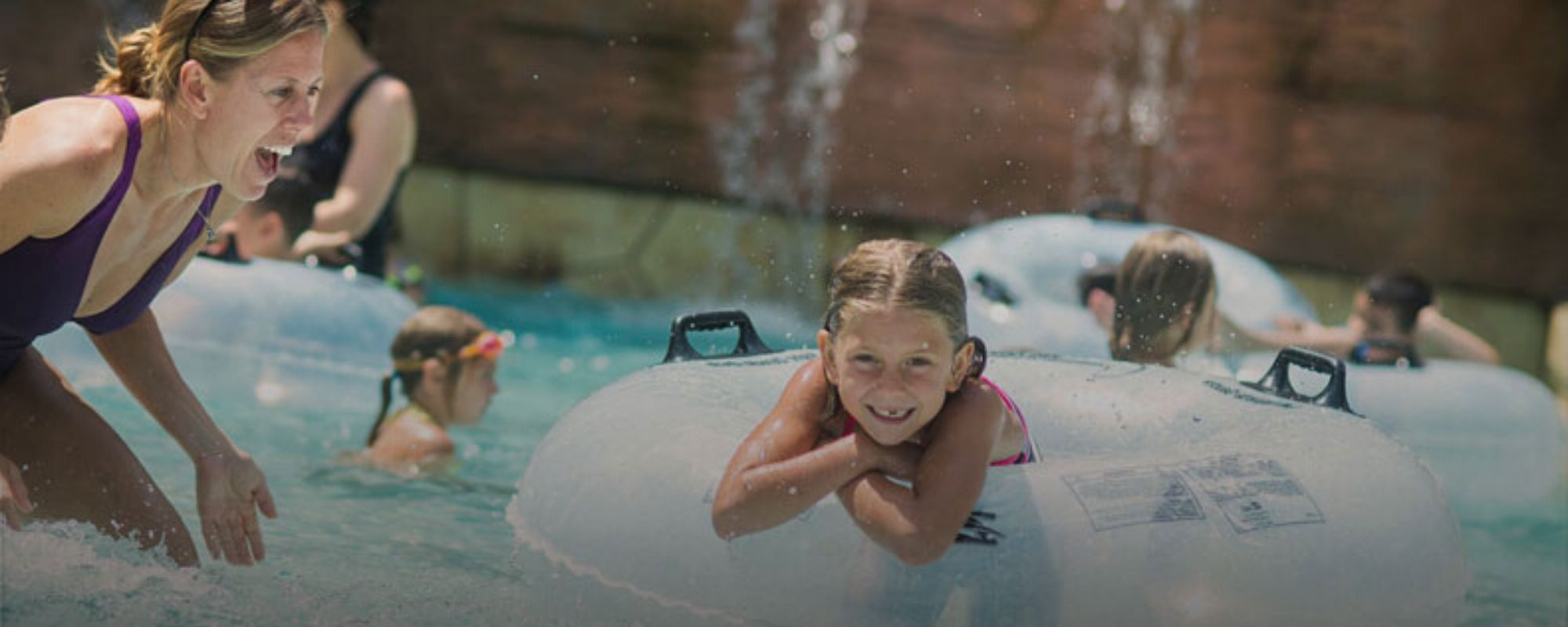 girl smiling in the water on a water tube