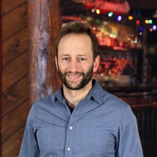 The author standing in front of a log cabin