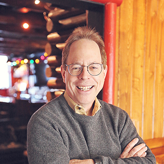 The author standing in front of a log cabin