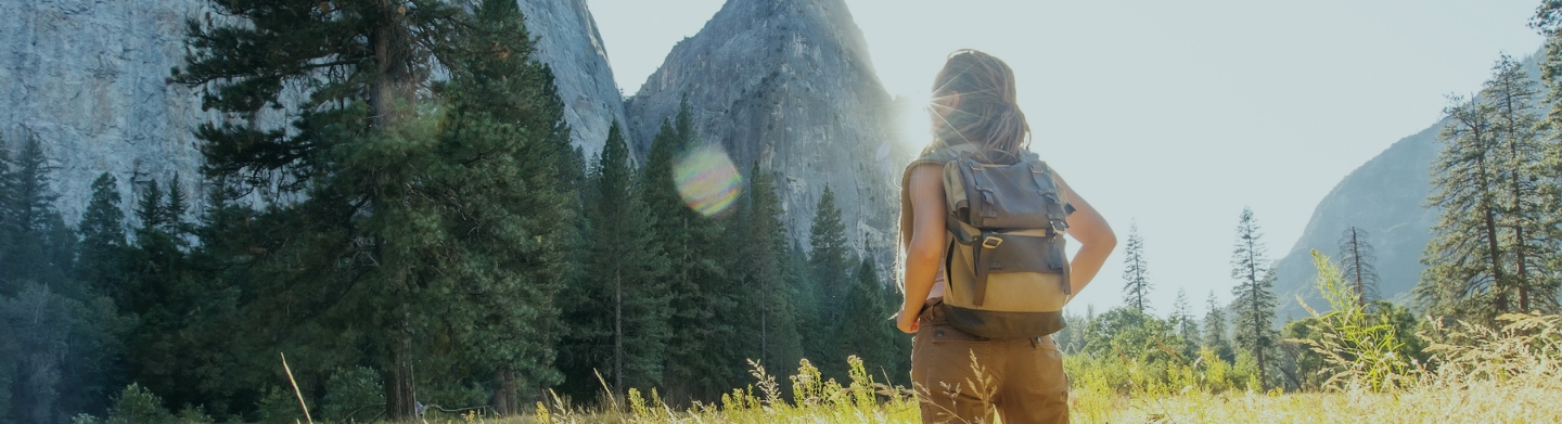 hiker with tall grass and mountains