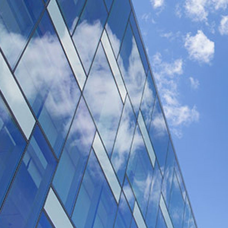 sky reflecting on glass windows of a building