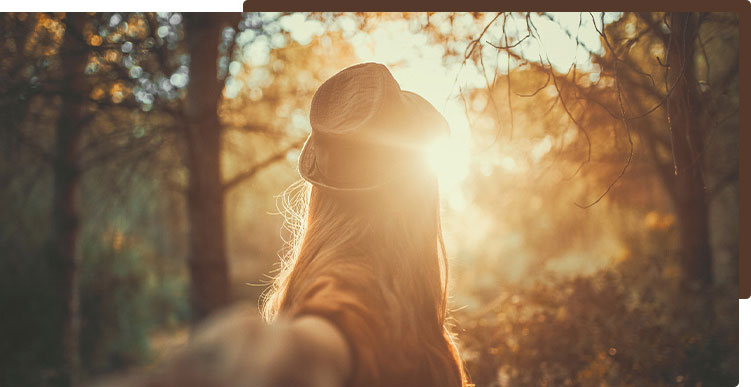 woman in silhouette in sunlit forest