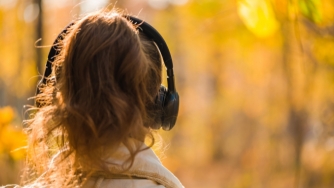 woman in forest with headphones