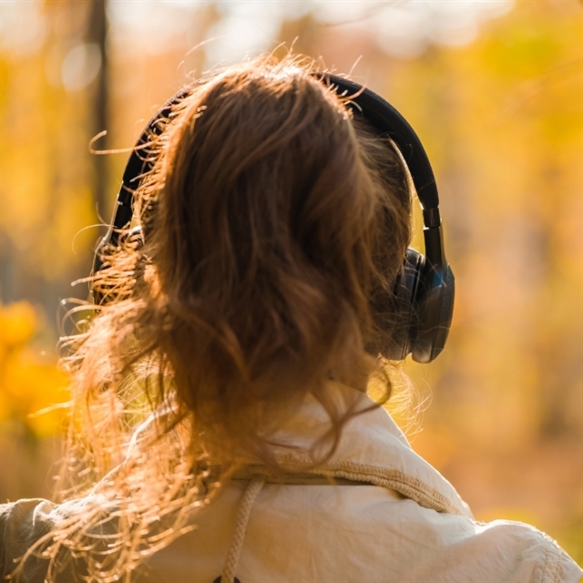 woman with headphones in the woods
